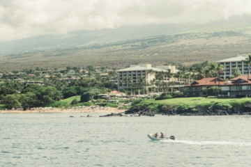 boat in ocean with island in background